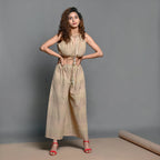 Front View of a Model wearing Beige Striped Handwoven Cotton Plunge Neck Blouson Jumpsuit