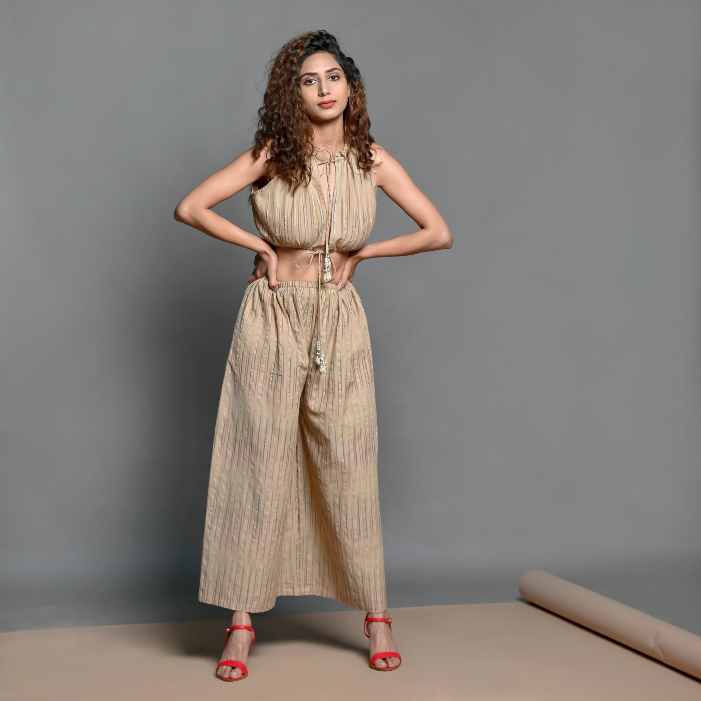 Front View of a Model wearing Beige Striped Handwoven Cotton Plunge Neck Blouson Jumpsuit