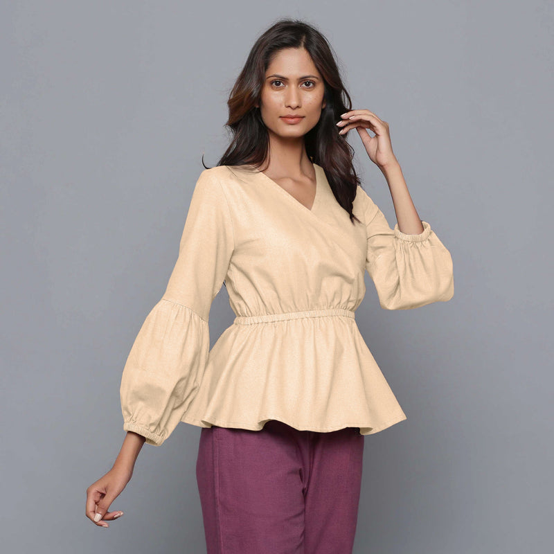Front View of a Model wearing Beige V-Neck Flannel Peplum Top