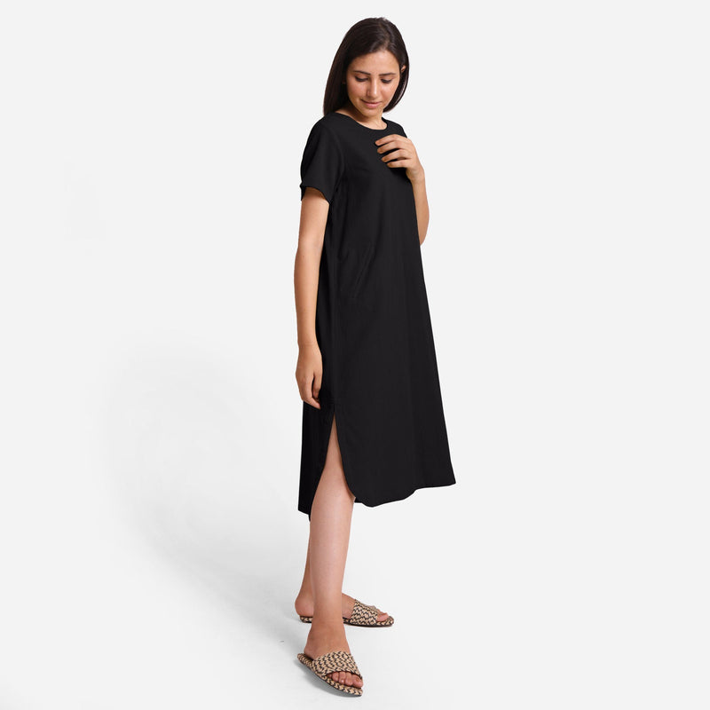 Right View of a Model wearing Black Cotton Welt Pocket Shift Dress