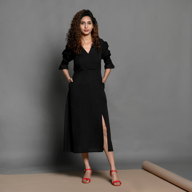 Front View of a Model wearing Black Handspun Cotton Surplice Neck Pleated Midi Dress