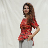 Left View of a Model wearing Brick Red Floral Block Printed Cotton Peplum Top