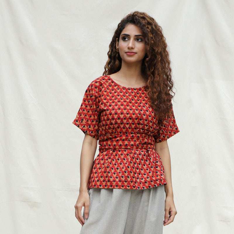 Front View of a Model wearing Brick Red Floral Block Printed Cotton Peplum Top