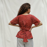 Back View of a Model wearing Brick Red Floral Block Printed Cotton Peplum Top