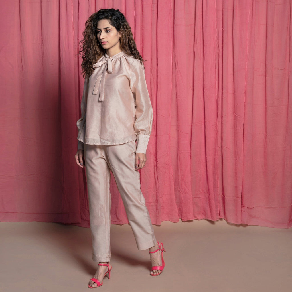 Left View of a Model wearing Champagne Cotton Chanderi Flared Tie Neck Top