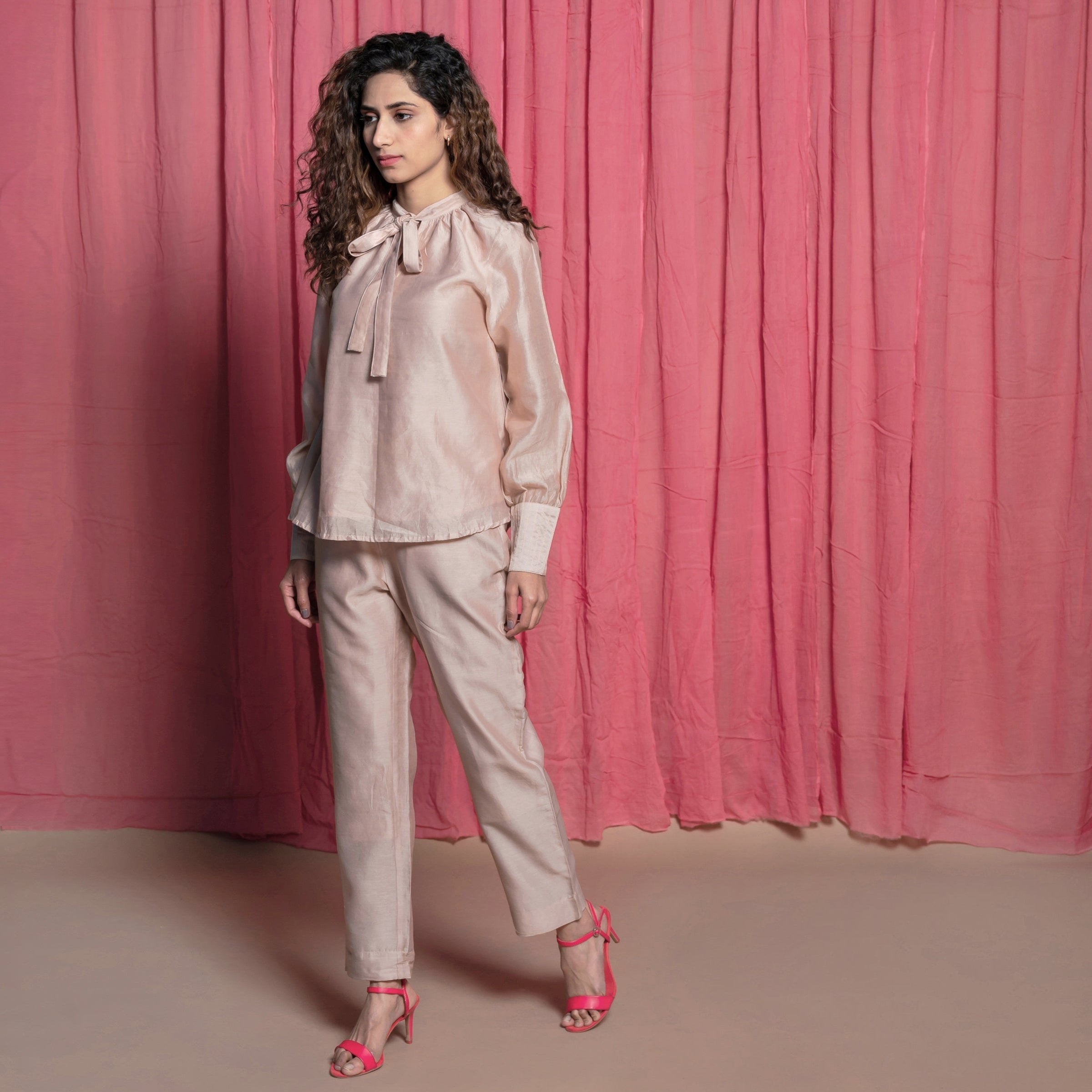 Left View of a Model wearing Champagne Cotton Chanderi Flared Tie Neck Top