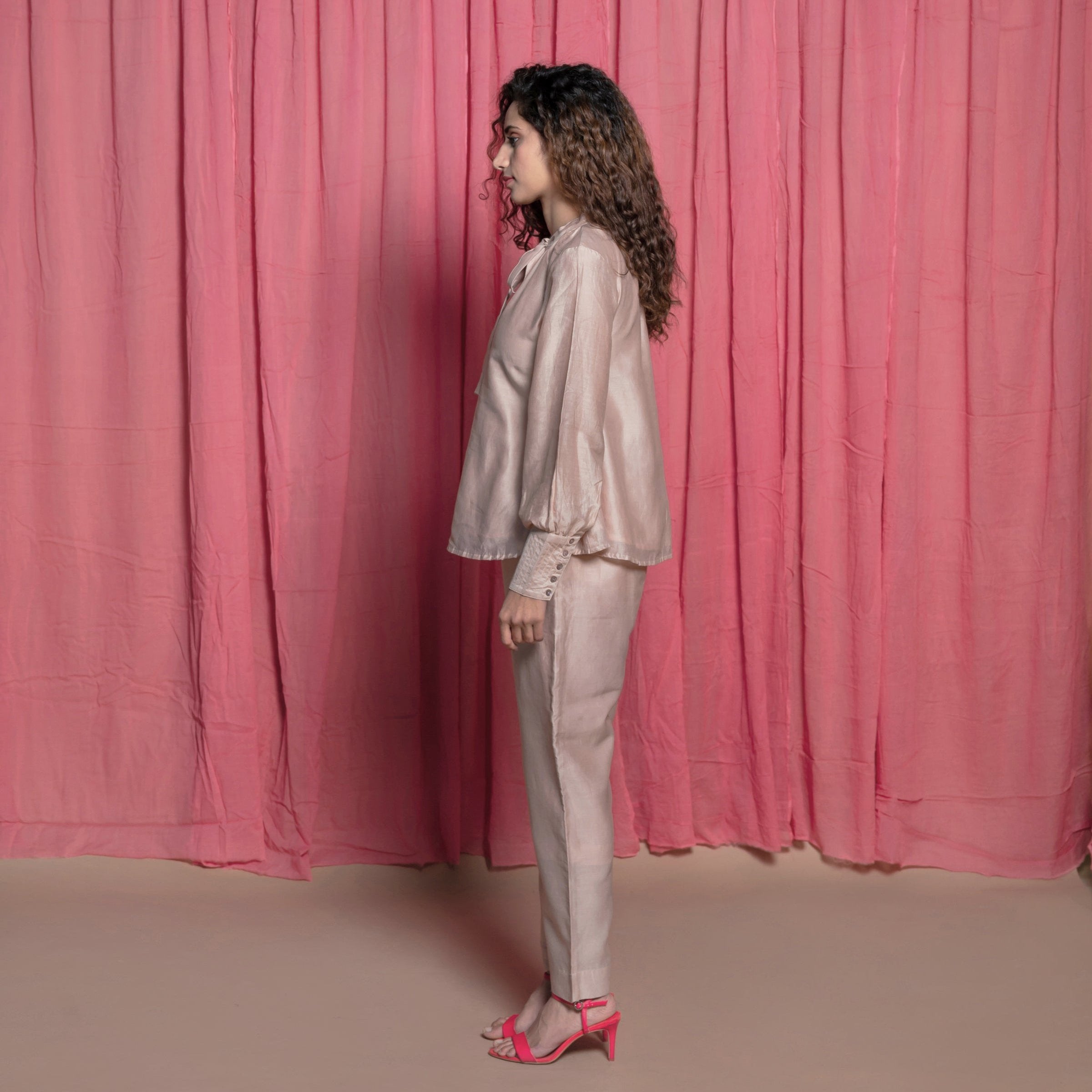 Left View of a Model wearing Champagne Cotton Chanderi Flared Tie Neck Top