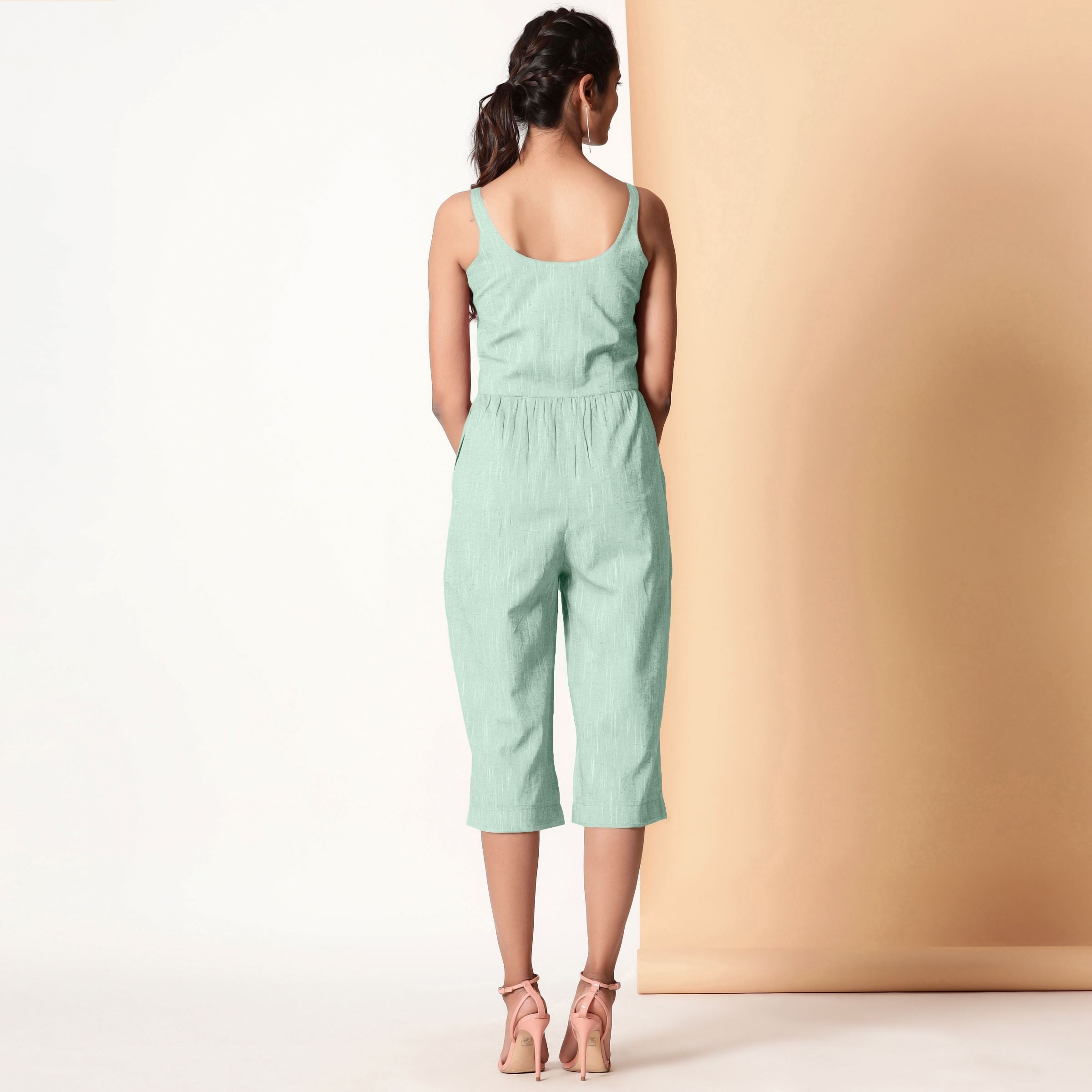 Back View of a Model wearing Aqua Sleeveless Cotton Button-Down Midi Jumpsuit
