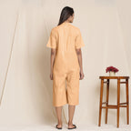 Back View of a Model wearing Yellow Cotton High Neck Pleated Midi Jumpsuit