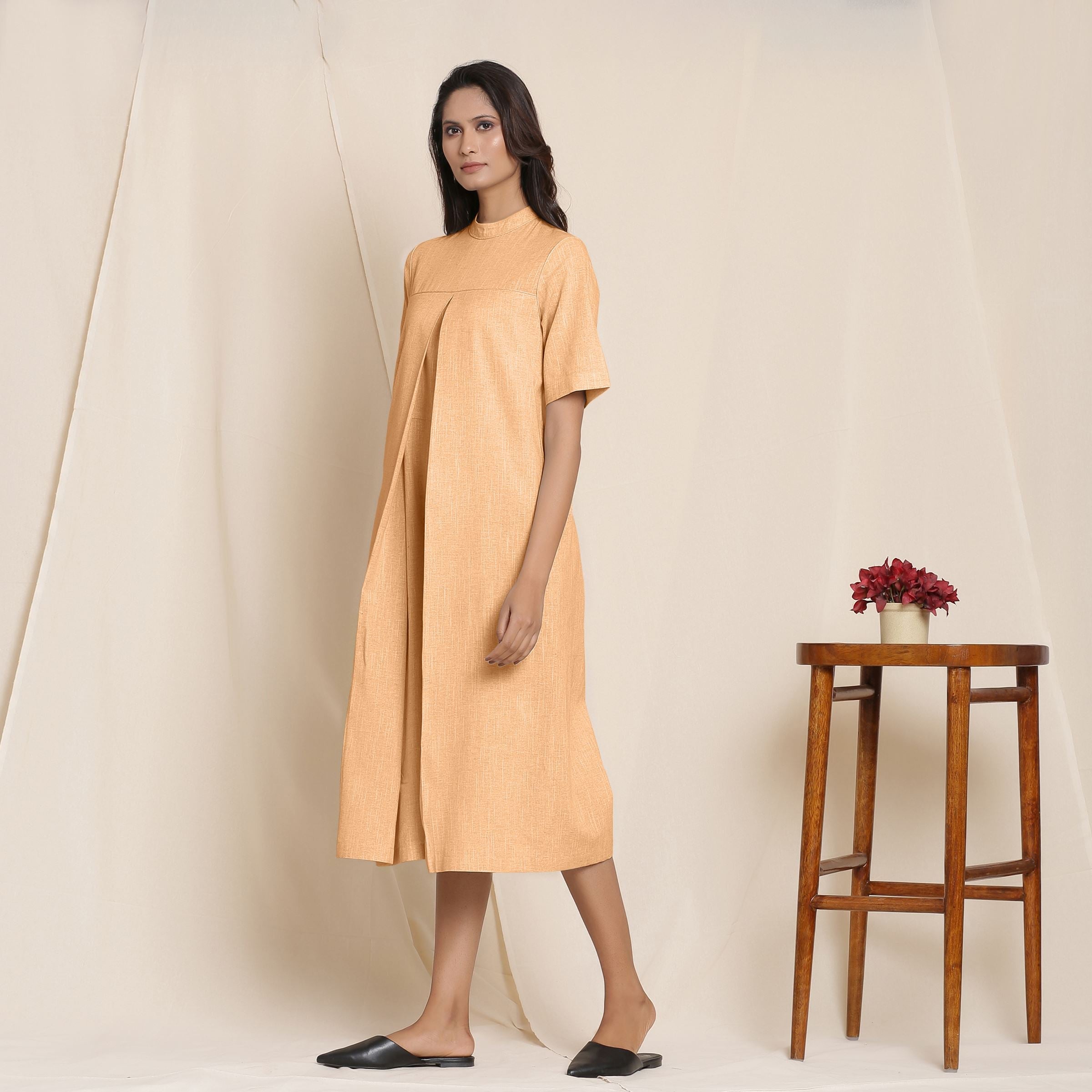 Left View of a Model wearing Yellow Cotton High Neck Pleated Midi Jumpsuit