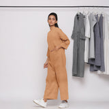 Left View of a Model wearing Desert Yellow 100% Linen High Neck Jumpsuit