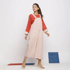 Right View of a Model wearing Ecru and Brick Red Striped Vegetable Dyed Cotton Pinafore Jumpsuit
