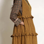 Right Detail of a Model wearing Golden Oak Tier Pinafore Frilled Dress