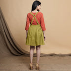 Back View of a Model wearing Green Pleated Cotton Flax Knee Length Criss-Cross Back Dress
