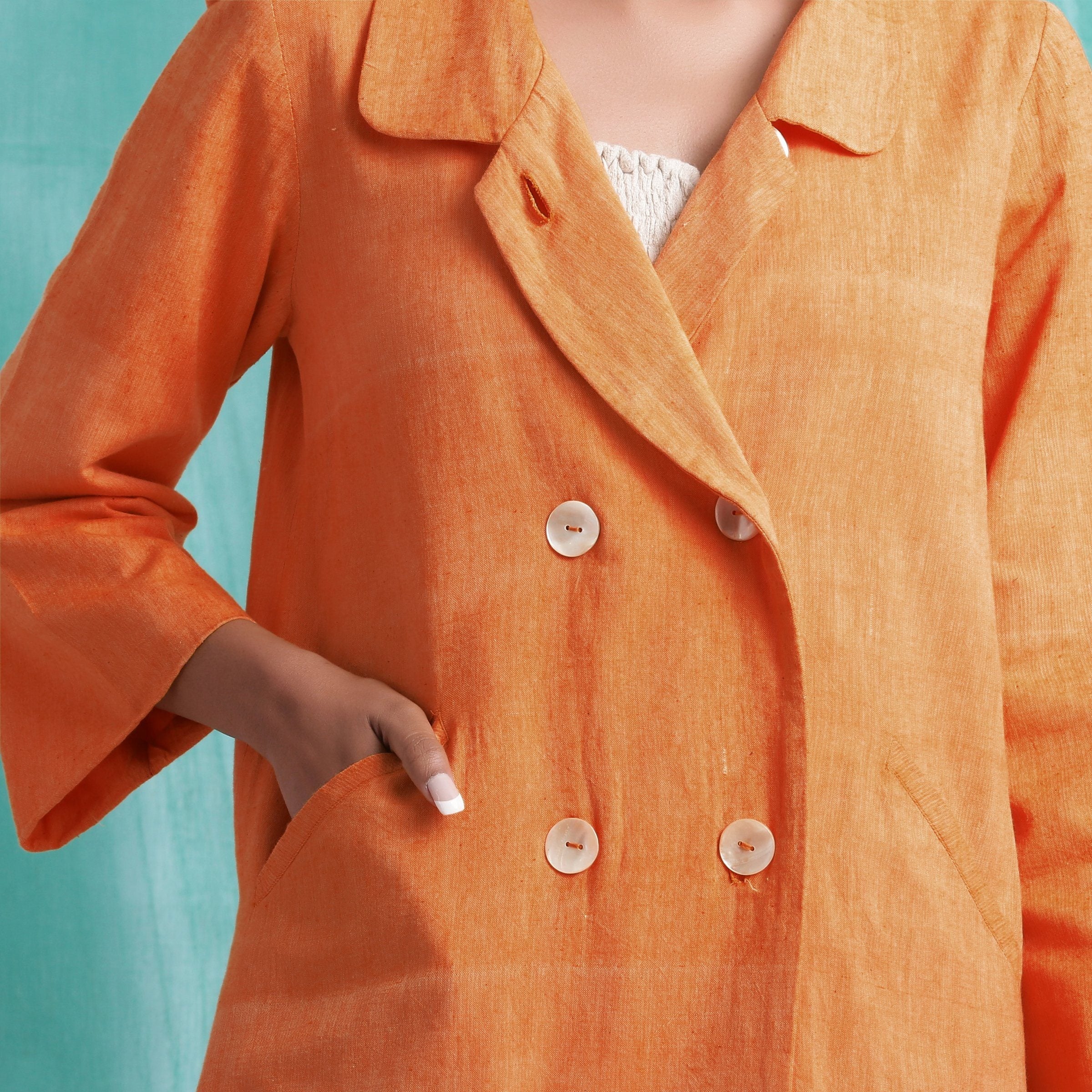 Front Detail of a Model wearing Handwoven Orange Welt Pocket Coat