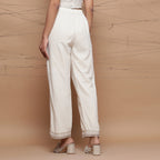 Back View of a Model wearing Ecru Jute Laced Cotton Muslin Mid-Rise Elasticated Pant