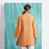 Back View of a Model wearing Melon Orange Welt Pocket Handwoven Coat