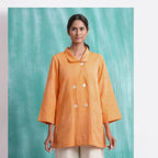Front View of a Model wearing Melon Orange Welt Pocket Handwoven Coat