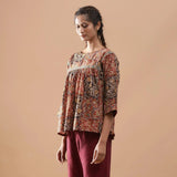 Left View of a Model wearing Muddy Red Block Print Cotton Kalamkari Top