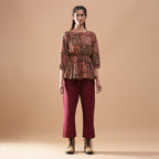 Front View of a Model wearing Muddy Red Kalamkari Block Print Cotton Peplum Top