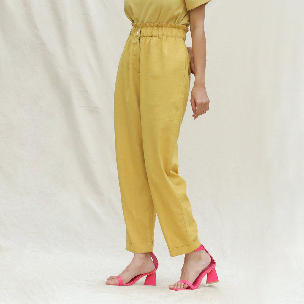 Left View of a Model wearing Mustard Handspun Cotton High-Rise Elasticated Paperbag Pant