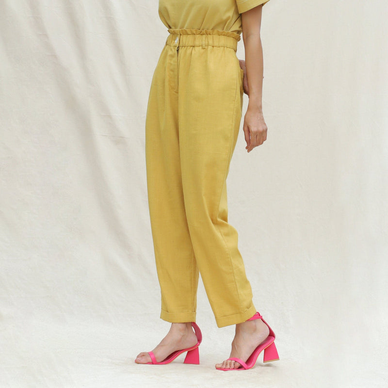 Left View of a Model wearing Mustard Handspun Cotton High-Rise Elasticated Paperbag Pant