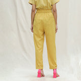 Back View of a Model wearing Mustard Handspun Cotton High-Rise Elasticated Paperbag Pant