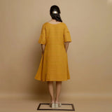 Back View of a Model wearing Mustard Striped Handwoven Godet Dress