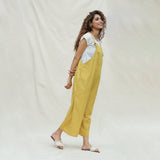 Right View of a Model wearing Mustard Vegetable Dyed Cotton Midi Dungaree Jumpsuit
