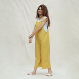 Left View of a Model wearing Mustard Vegetable Dyed Cotton Midi Dungaree Jumpsuit