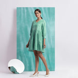 Left View of a Model wearing Ocean Green Handspun Cotton V-Neck Gathered Short Dress