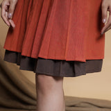 Close View of a Model wearing Orange and Brown Reversible Pleated Flared Skirt