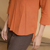 Left Detail of a Model wearing Orange Yarn Dyed Cotton Pleated High-Low Top
