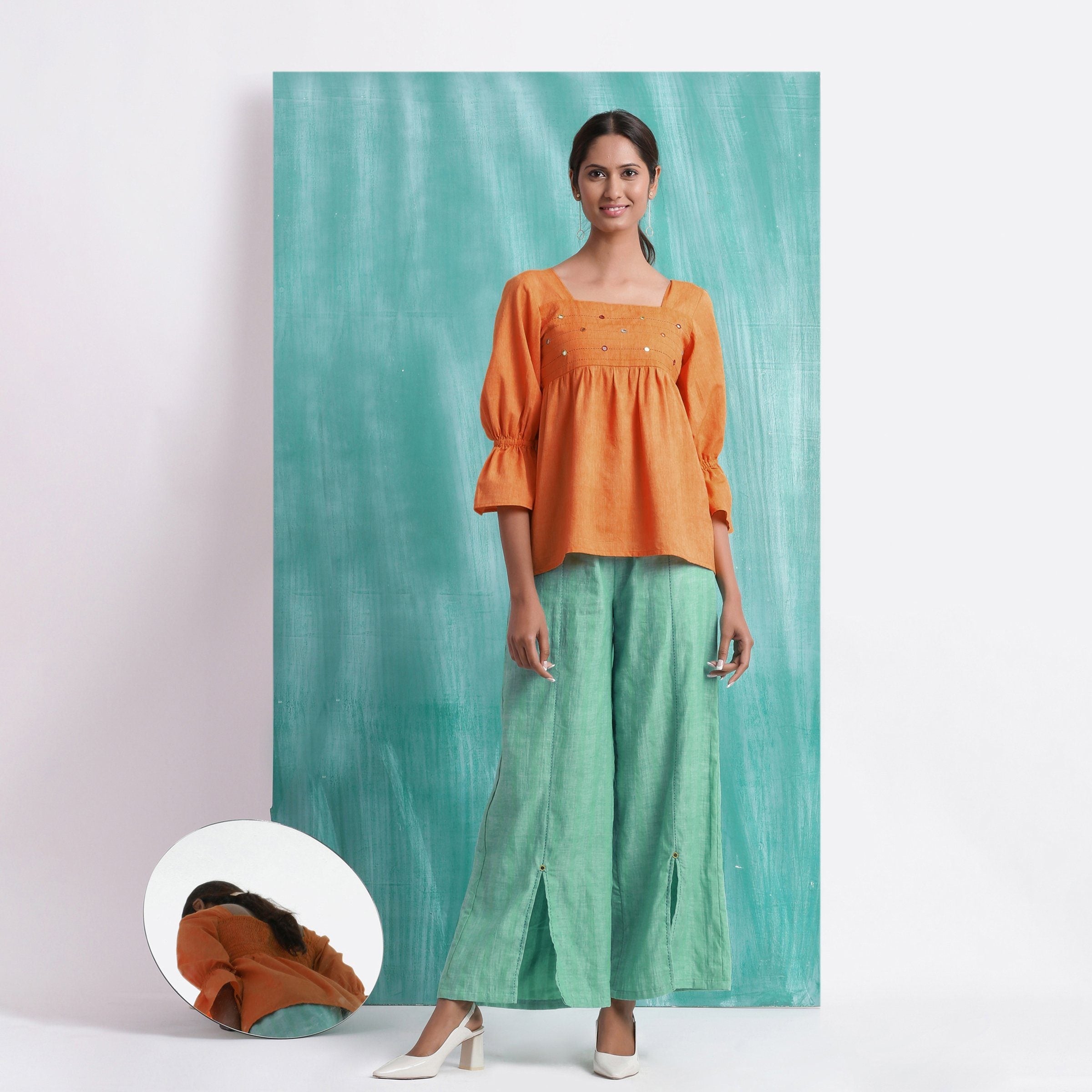 Front View of a Model wearing Orange Handspun Mirror Work Yoked Top