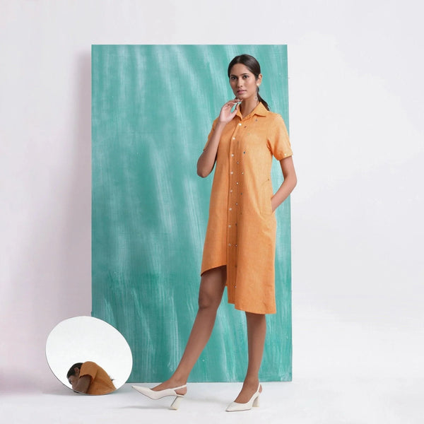 Left View of a Model wearing Orange Mirrored Asymmetrical Shirt Dress