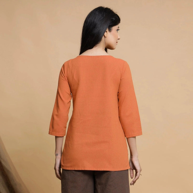 Back View of a Model wearing Orange Yarn Dyed Cotton Pleated High-Low Top