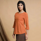 Left View of a Model wearing Orange Yarn Dyed Cotton Pleated High-Low Top