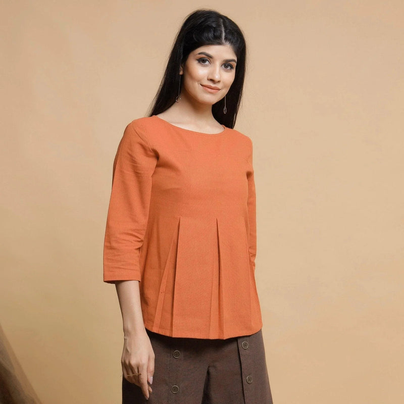 Right View of a Model wearing Orange Yarn Dyed Cotton Pleated High-Low Top