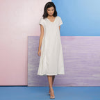 Right View of a Model wearing Organic Cotton White Beaded Lace Flare Dress