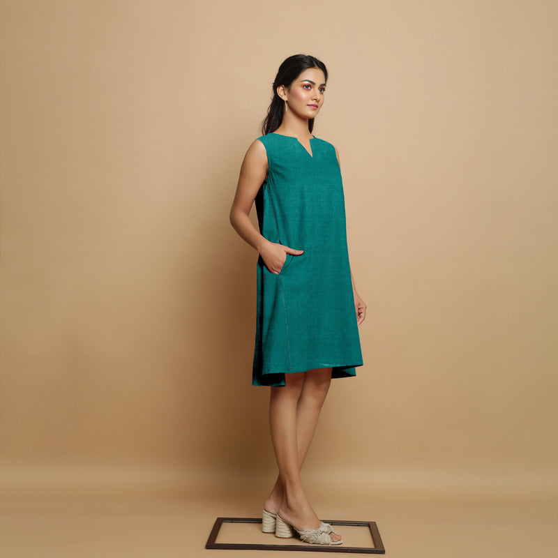 Right View of a Model wearing Pine Green Linen Hand Embroidered Knee-Length Godet Dress