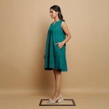 Left View of a Model wearing Pine Green Linen Hand Embroidered Knee-Length Godet Dress