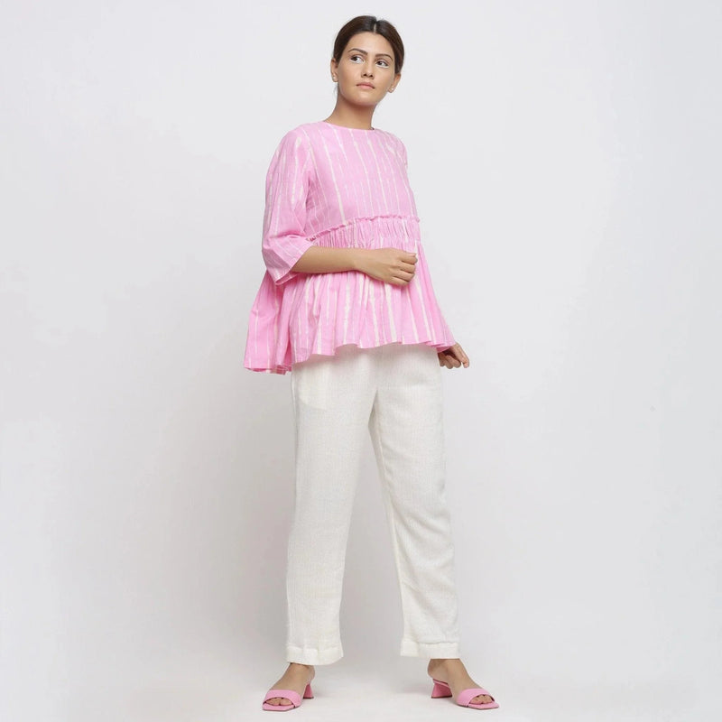 Right View of a Model wearing Pink Cotton Tie-Dye Cotton Gathered Flared Top