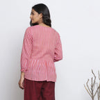 Back View of a Model wearing Pink Handspun Button-Down Peplum Top