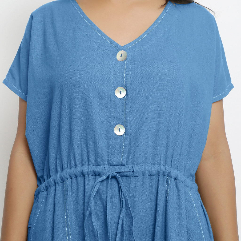Front Detail of a Model wearing Powder Blue Vegetable Dyed Button-Down Jumpsuit