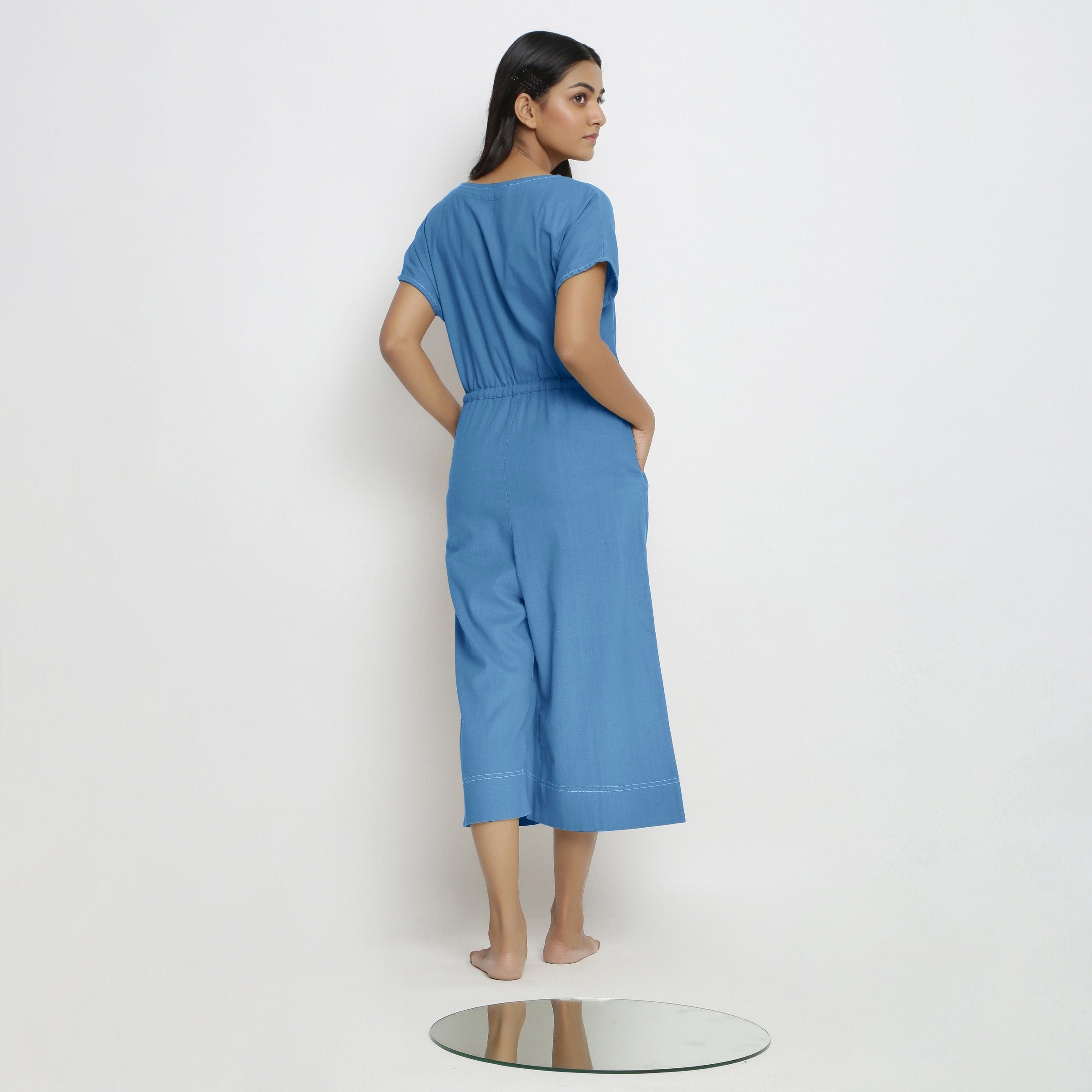 Back View of a Model wearing Powder Blue Vegetable Dyed Button-Down Jumpsuit