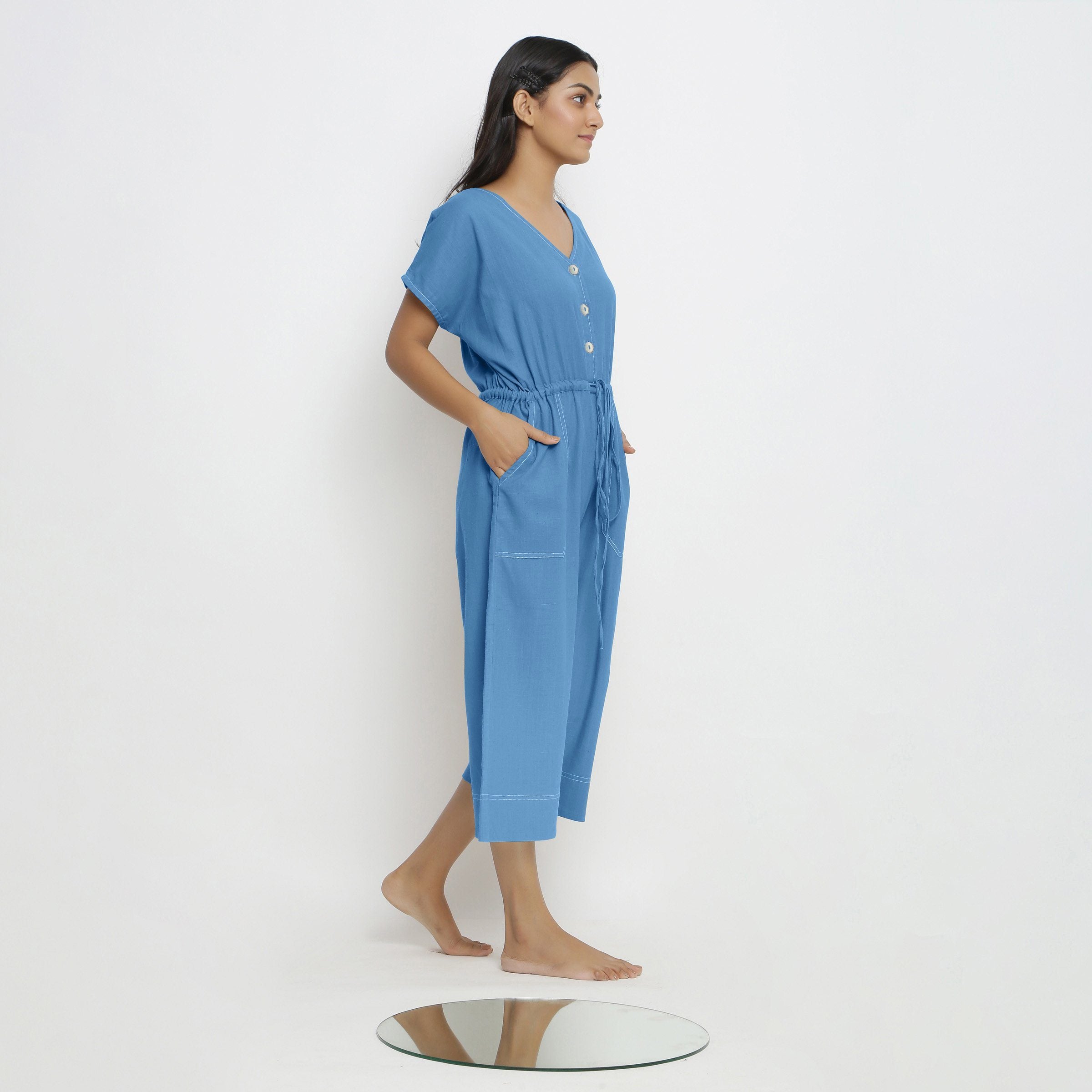 Right View of a Model wearing Powder Blue Vegetable Dyed Button-Down Jumpsuit