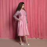 Right View of a Model wearing Powder Pink Cotton Block Printed Knee Length Frilled Dress