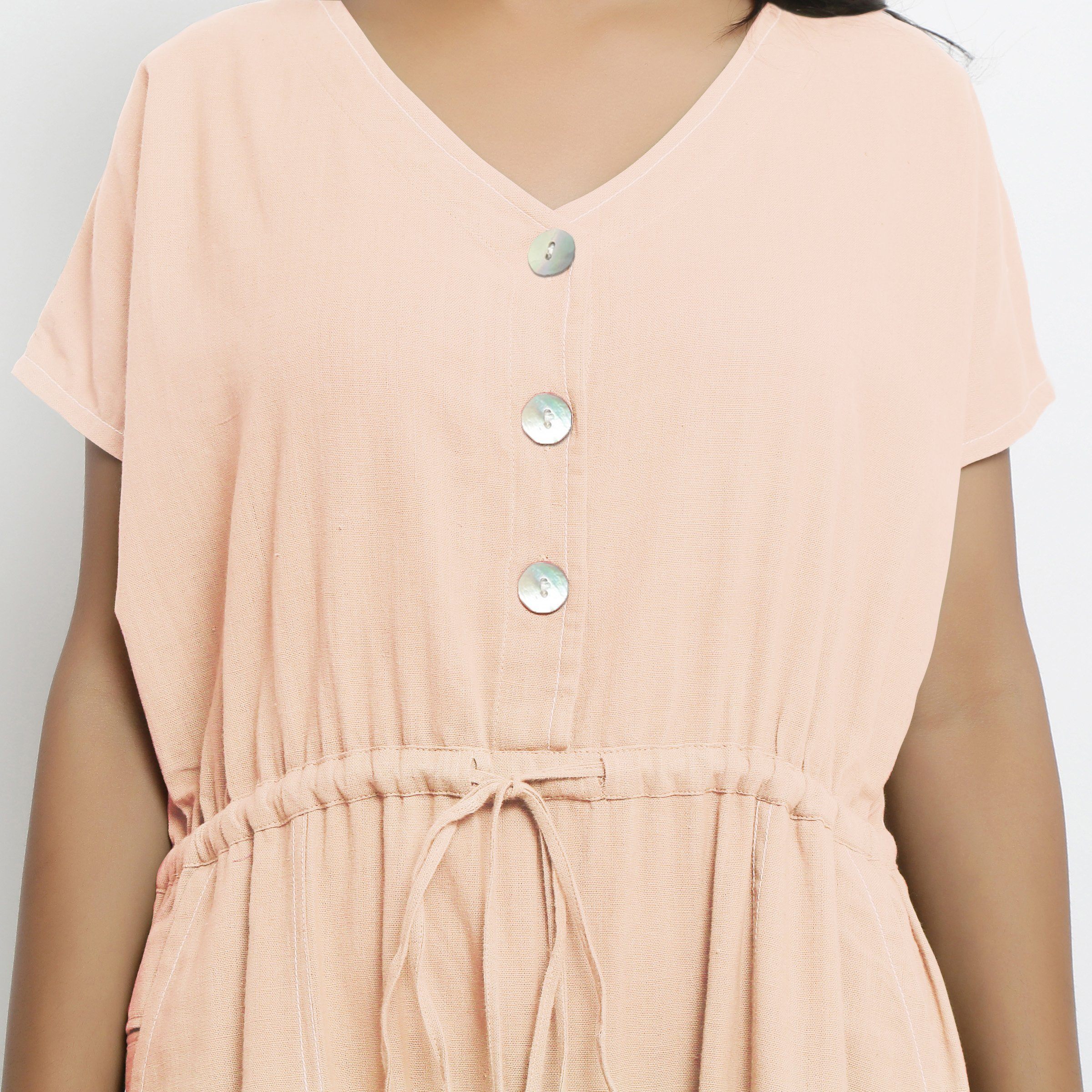 Front Detail of a Model wearing Powder Pink Vegetable Dyed Button-Down Jumpsuit