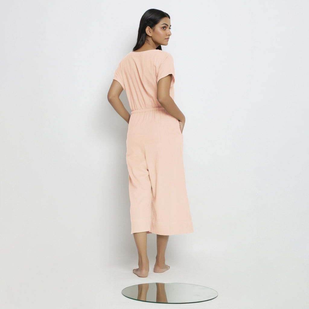 Back View of a Model wearing Powder Pink Vegetable Dyed Button-Down Jumpsuit