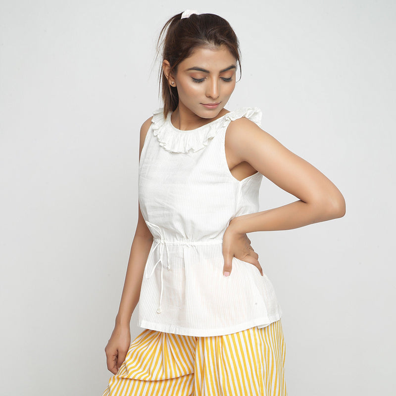 Left View of a Model wearing Ruffled Off-White Cotton Peplum Top